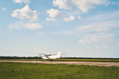 Güzel bulutlu gökyüzünün altında hafif uçaklar pistte