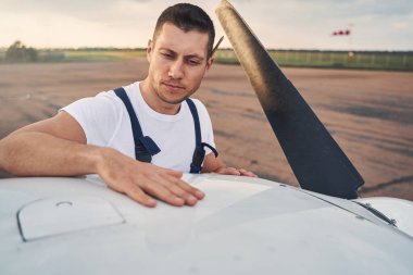 Uçak tamircisi, havaalanının dışındaki uçağı inceliyor.