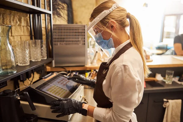 Beschermde kassier raakt het scherm tijdens het maken van de rekening — Stockfoto