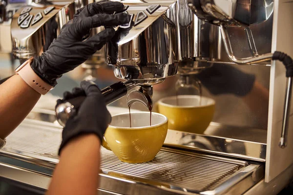 Café caliente que se vierte en la taza amarilla en la cafetería —  Fotos de Stock