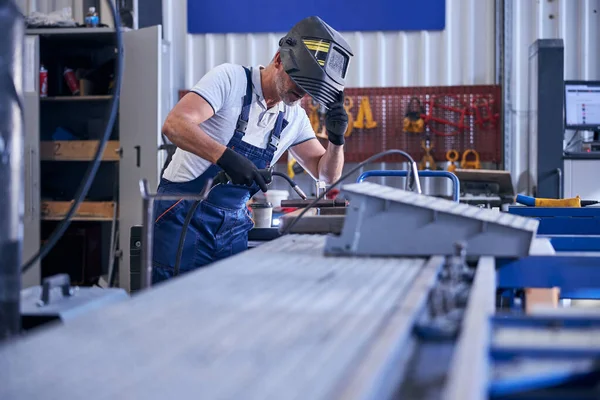 Mechanica in lashelm aan het werk in garage — Stockfoto