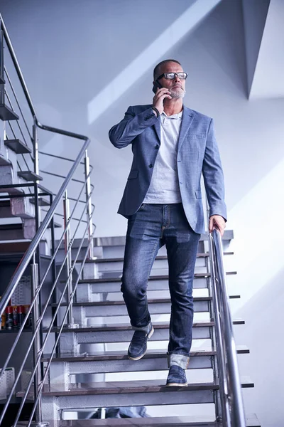 階段に立って電話の会話をしているハンサムな男 — ストック写真