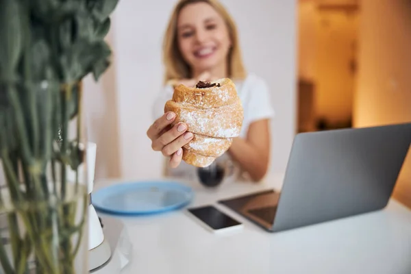 Foto focalizzata sulla mano femminile che tiene croissant — Foto Stock