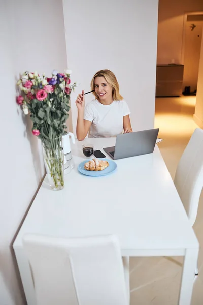 Une femme heureuse assise devant son ordinateur portable — Photo