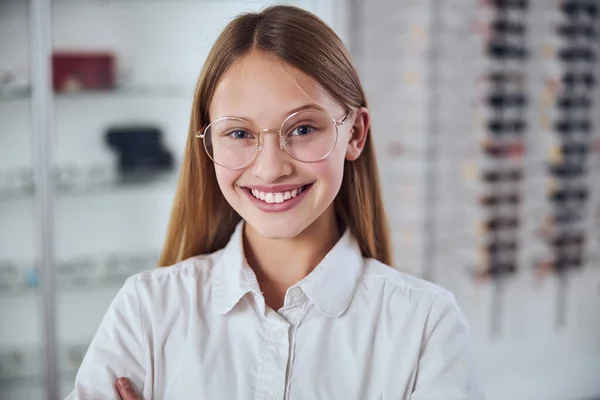 Blond blank schoolmeisje besteedt tijd in opticien winkel — Stockfoto