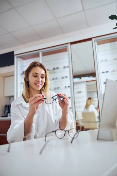 穿着时髦衣服的白人成年女性在眼镜店选择和试用眼镜 — 图库照片