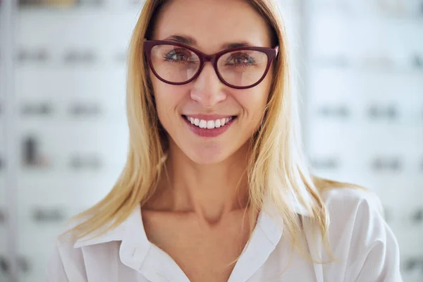 Feliz sonriente rubia caucásica mujer tratando de conjunto de gafas —  Fotos de Stock