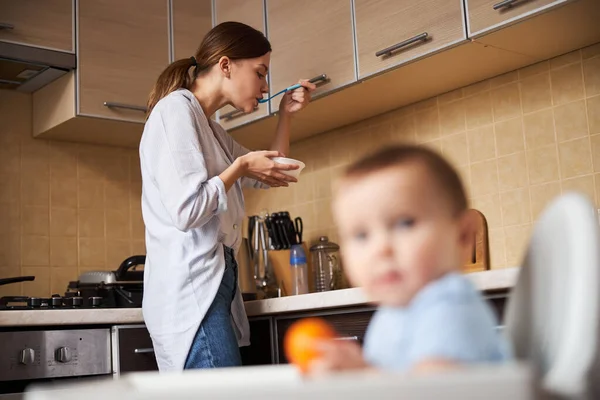 Donna attenta a provare la zuppa prima di nutrire suo figlio — Foto Stock