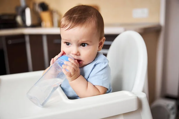 Niñito serio mordiendo pezón en la botella — Foto de Stock