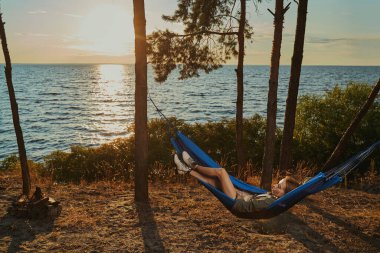 Sırt çantalı hamakta dinleniyor.