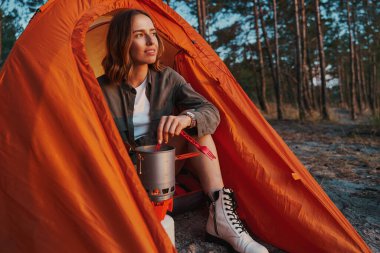 Kamp sırasında çayı karıştıran mutlu bayan.