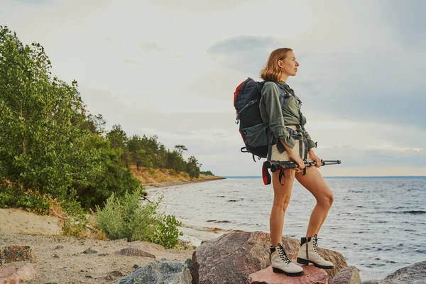 Donna sportiva in piedi su rocce a riva del fiume — Foto Stock