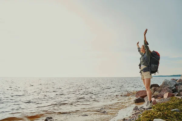 Escursionista eccitato alzando le braccia mentre si gode la giornata — Foto Stock