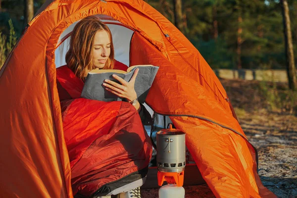 Femmina escursionista sta leggendo libro all'interno tenda — Foto Stock