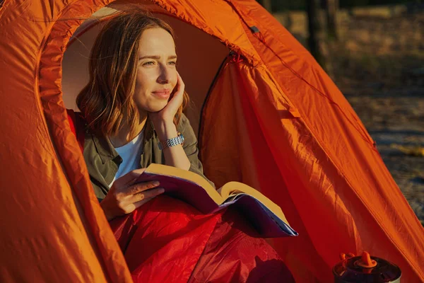 Zaino in spalla soddisfatto guardando a parte dal libro al tramonto — Foto Stock