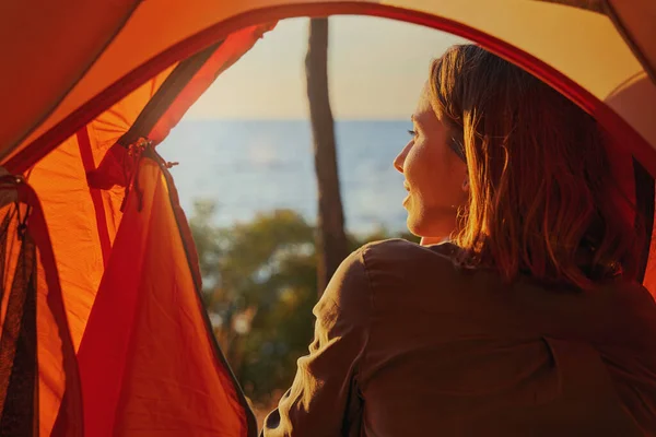 Persona sorridente gioiosamente al tramonto dalla tenda — Foto Stock