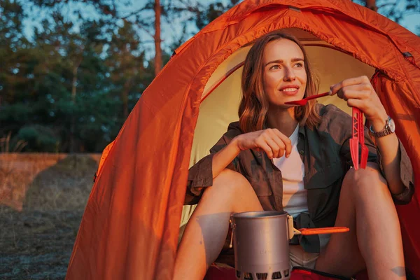 Escursionista bere il tè dal cucchiaio durante il campeggio — Foto Stock