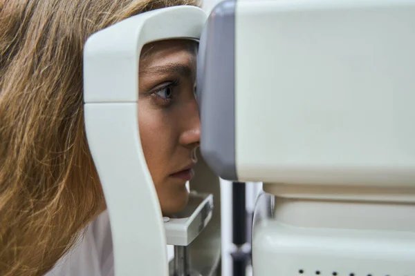 Hermosa mujer joven teniendo ojo examinando en la clínica — Foto de Stock