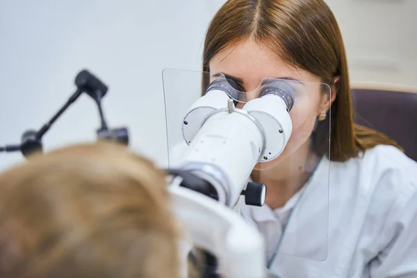 Лікар перевіряє зір жінки з офтальмологічним обладнанням — стокове фото