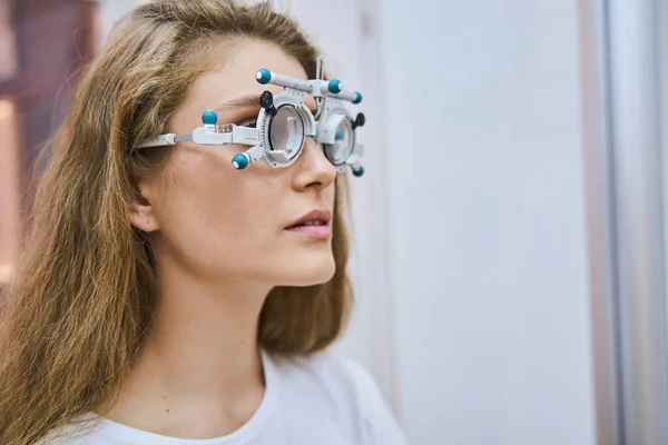 Hermosa mujer joven con marco de lente de ensayo óptico —  Fotos de Stock