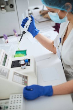 Biyokimyacı hematolojik test için pipetör kullanıyor.