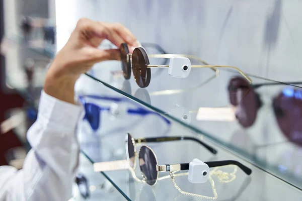 Gafas de sol de mano de mujer en tienda óptica —  Fotos de Stock