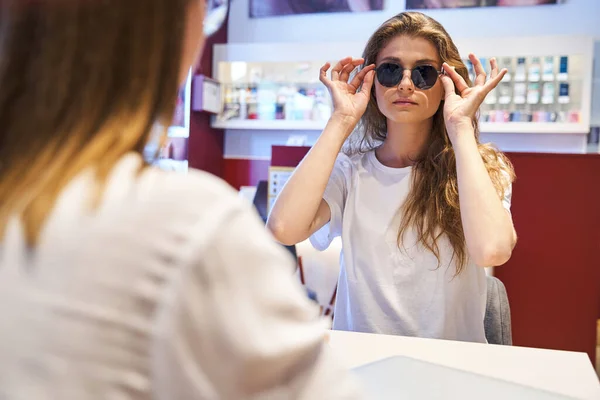 Mujer bonita teniendo reunión con óptico en tienda óptica —  Fotos de Stock