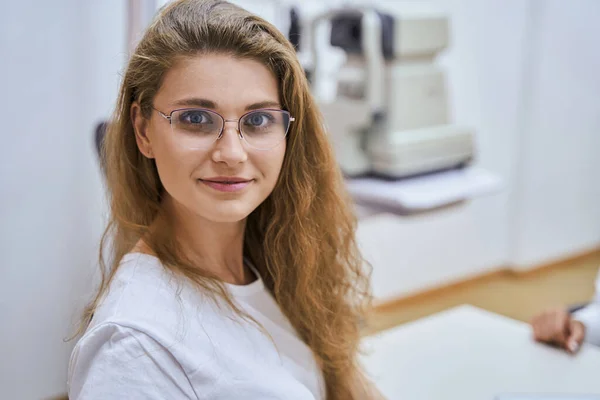 Όμορφη νεαρή γυναίκα με γυαλιά επισκέπτεται οπτική κλινική — Φωτογραφία Αρχείου