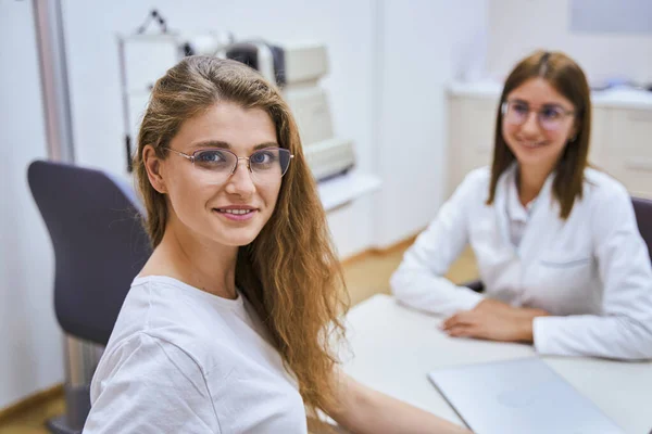 在诊所与眼科医生预约的戴眼镜的漂亮女人 — 图库照片