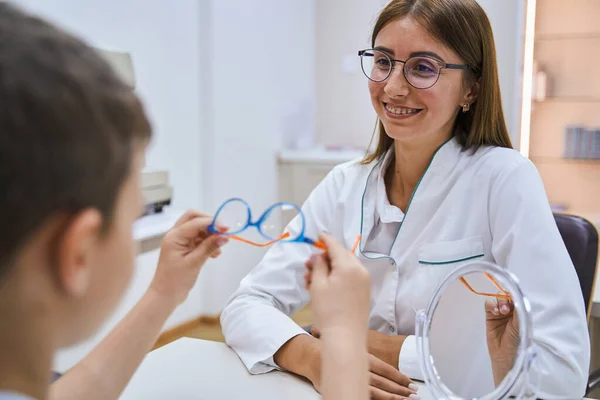 Glada optiker förskrivning glasögon till pojke på kliniken — Stockfoto