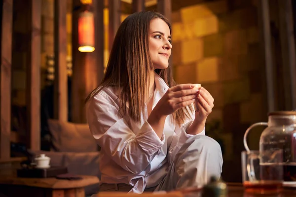 Чарівна молода жінка п'є чай в кафе — стокове фото