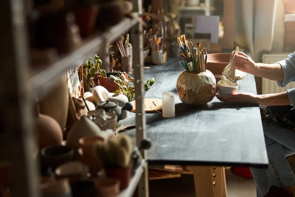 Female ceramic artist painting pottery in workshop — Stock Photo, Image