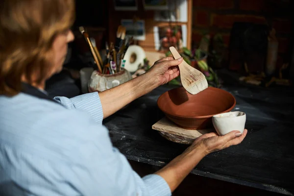Female ceramic artist painting pottery in workshop — Stock Photo, Image