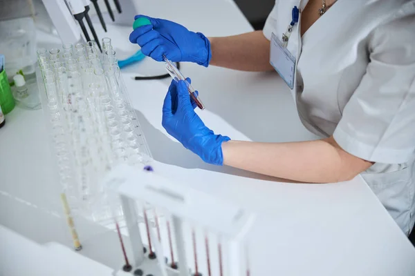 Ervaren biochemicus in steriele latex handschoenen die een laboratoriumanalyse uitvoert — Stockfoto