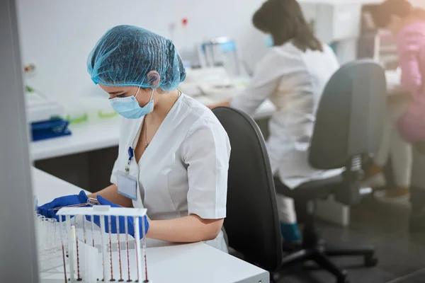 Bioquímico enfocado en guantes de látex estériles y mascarilla facial —  Fotos de Stock