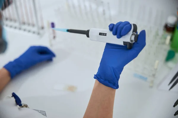 Bioquímico qualificado usando uma ferramenta de laboratório para um exame de sangue — Fotografia de Stock