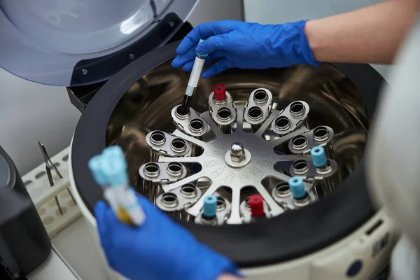 Lab technician using a centrifuge for a biochemical analysis — Stock Photo, Image