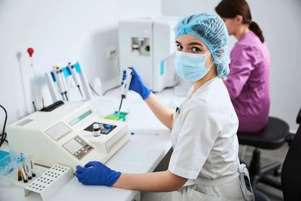 Bioquímico en una máscara facial posando para la cámara en el trabajo —  Fotos de Stock