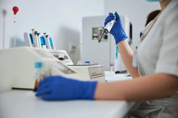 Female in latex gloves carrying out a coagulation test — Stock Photo, Image