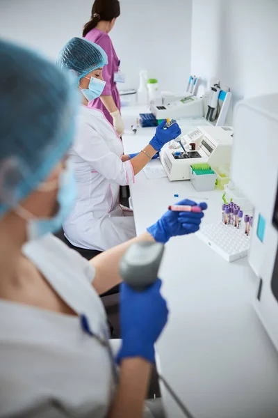 Científico dirigiendo un escáner de código de barras en la vacutainer — Foto de Stock