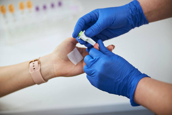 Lab technician performing a skin puncture procedure