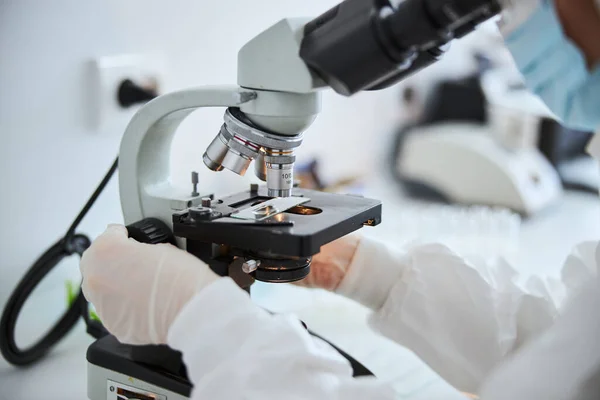 Técnico de laboratorio examinando células bajo el microscopio — Foto de Stock