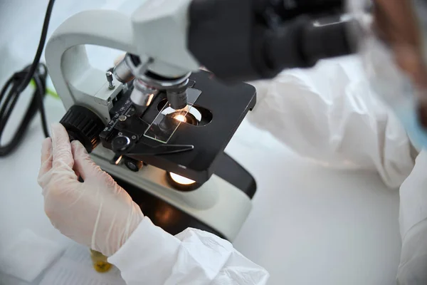 Microbiologist observing a microscopic specimen under the microscope — Stock Photo, Image