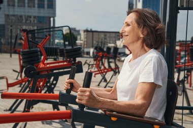 Neşeli olgun kadın antrenman çekirdeği spor alanında