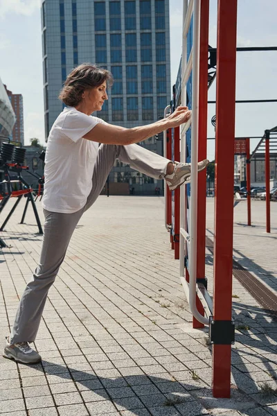 成熟した女性が屋外で柔軟性の演習を行うフィット — ストック写真