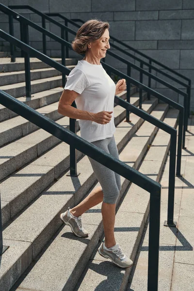 Mulher idosa feliz fazendo treinamento cardio ao ar livre — Fotografia de Stock