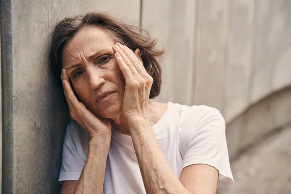 Aged female suffering from migraine in open air — Foto de Stock