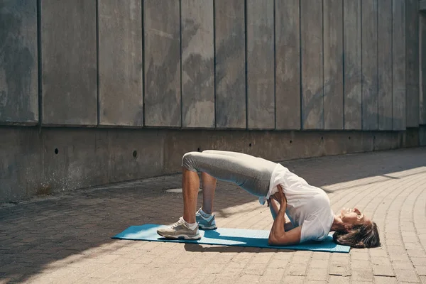 Magro mulher madura exercitando corpo ao ar livre — Fotografia de Stock