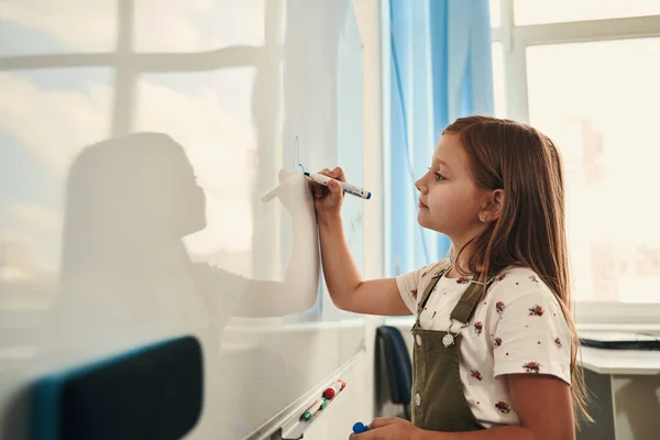 Zelfverzekerd kind is genieten van studeren op school — Stockfoto