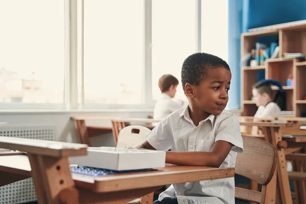 Tranquilo chico comportándose en silencio en la lección de la escuela —  Fotos de Stock